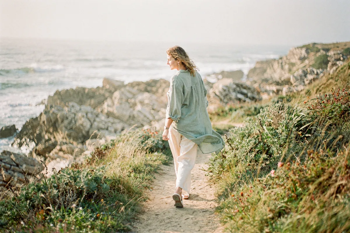 Une femme marche sur un sentier côtier